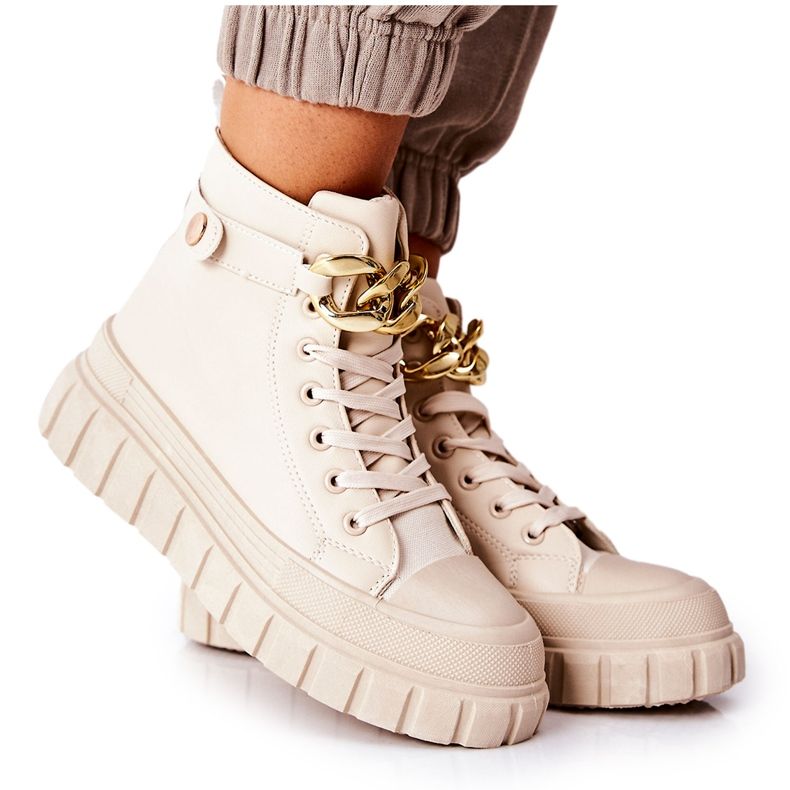 Magas tornacipők bézs állványokon aranysárga