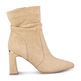 Bézs színű női csizma díszített oszlopon