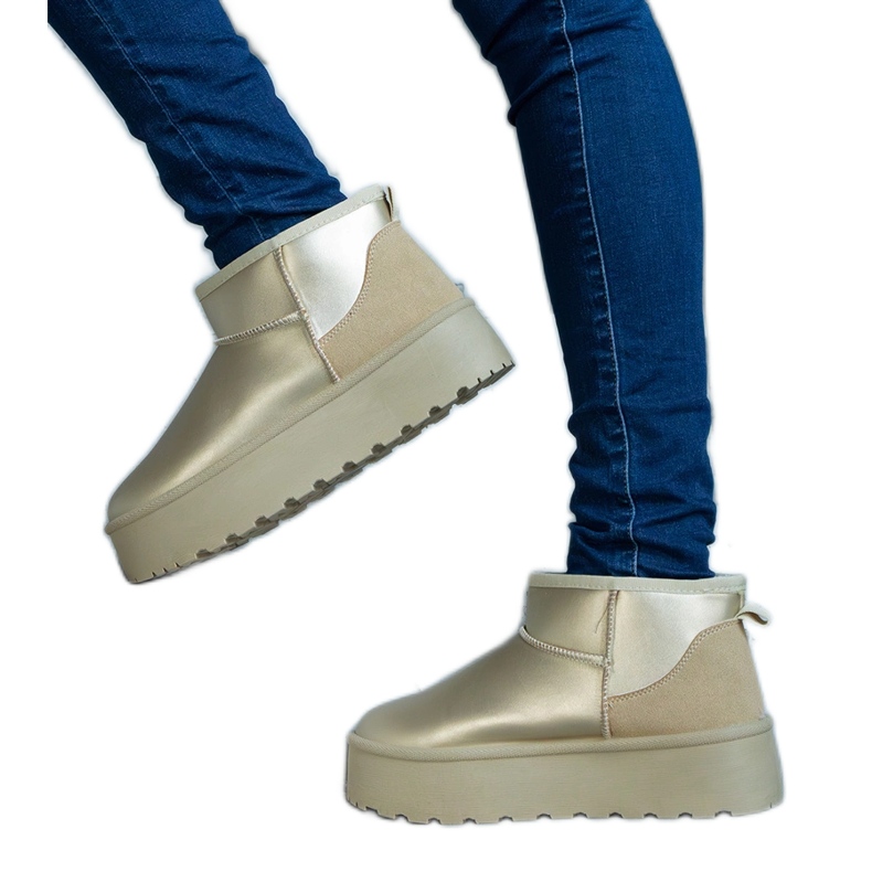 Arany alacsony hó csizma az emelvényen aranysárga