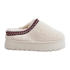 Világos bézs báránybőr papucs egy emelvényen szőrmével