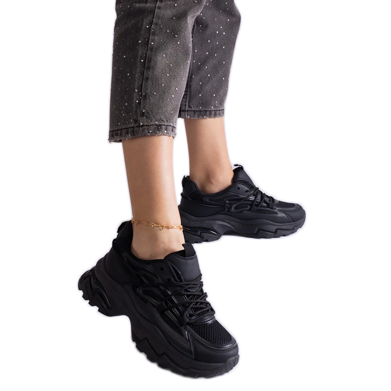 Fekete sport cipők egy hatalmas talpon