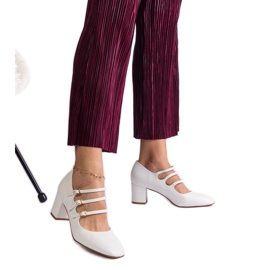 Fehér szivattyúk az oszlopon dekoratív csatokkal Fehér szivattyúk az oszlopon dekoratív csatokkal