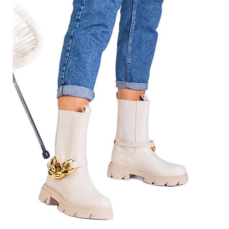 Bézs bokcsizmák egy hatalmas lánccal díszítve