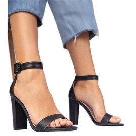 Fekete szandál az oszlopon rögzített a bokára