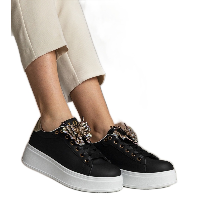 Fekete cipők, amelyek cirkonokkal ellátott pillangóval díszítik