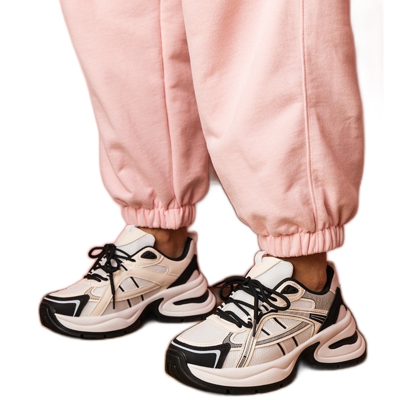 Fehér és fehér sport cipők egy hatalmas talpon