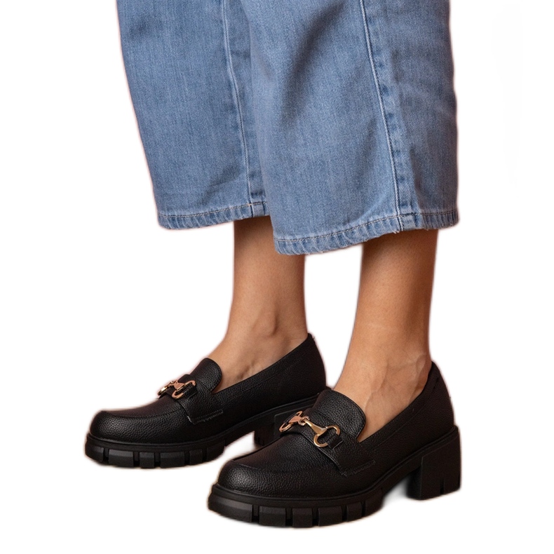 Fekete cipő egy alacsony oszlopon, arany dekorációval