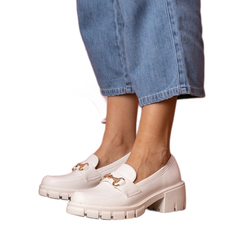 Fehér cipő egy alacsony oszlopon, arany díszgel