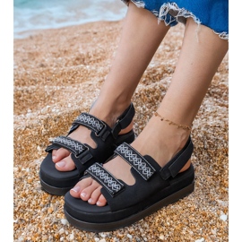 Fekete szandál hímzett csíkokkal a peronon