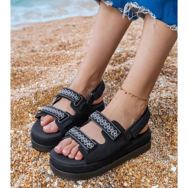 Fekete szandál hímzett csíkokkal a peronon