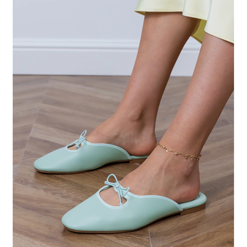 Zöld flip -flopok egy lapos talpra épülnek