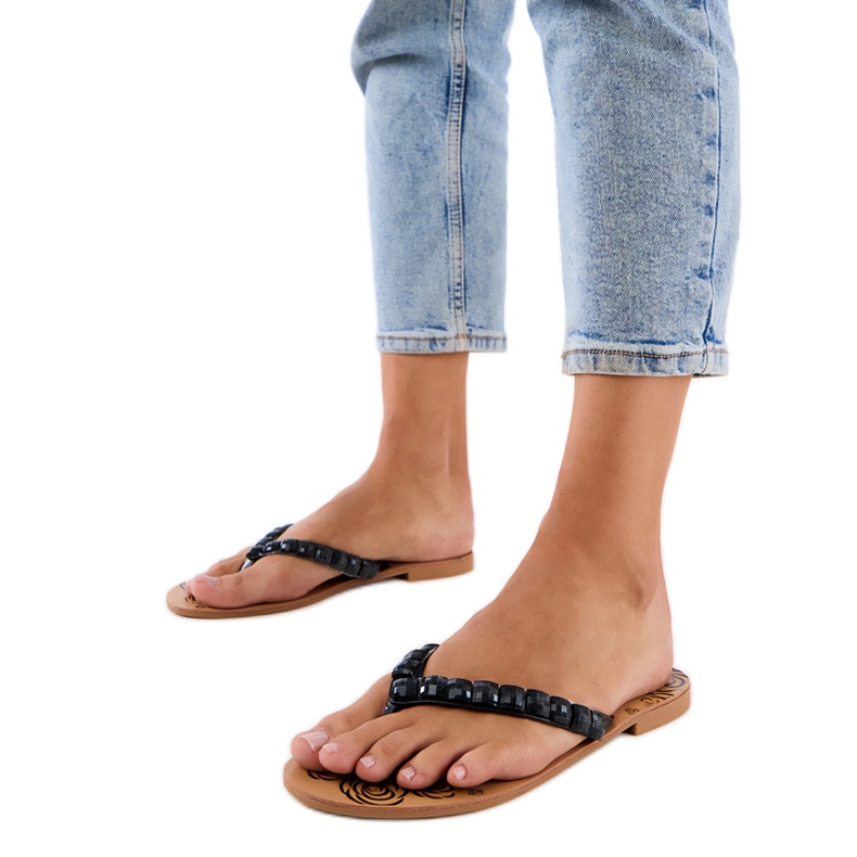 Fekete flip -flops flip -flopok, kavicsokkal díszítve