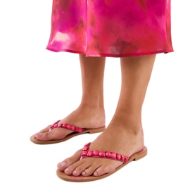 A rózsaszín flip flopok kavicsokkal díszítve