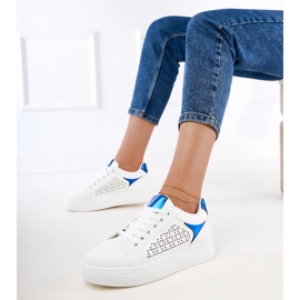 Fehér cipők kék betétekkel a peronon