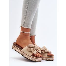 Bézs színű női papucsok egy emelvényen masnival Evatria 2