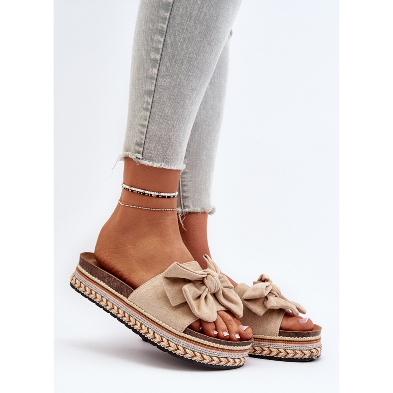 Bézs színű női papucsok egy emelvényen masnival Evatria 2