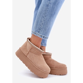 Díszítő hímzéssel ellátott bézs hócsizma emelvényen 1