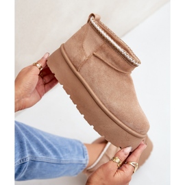 Díszítő hímzéssel ellátott bézs hócsizma emelvényen 2