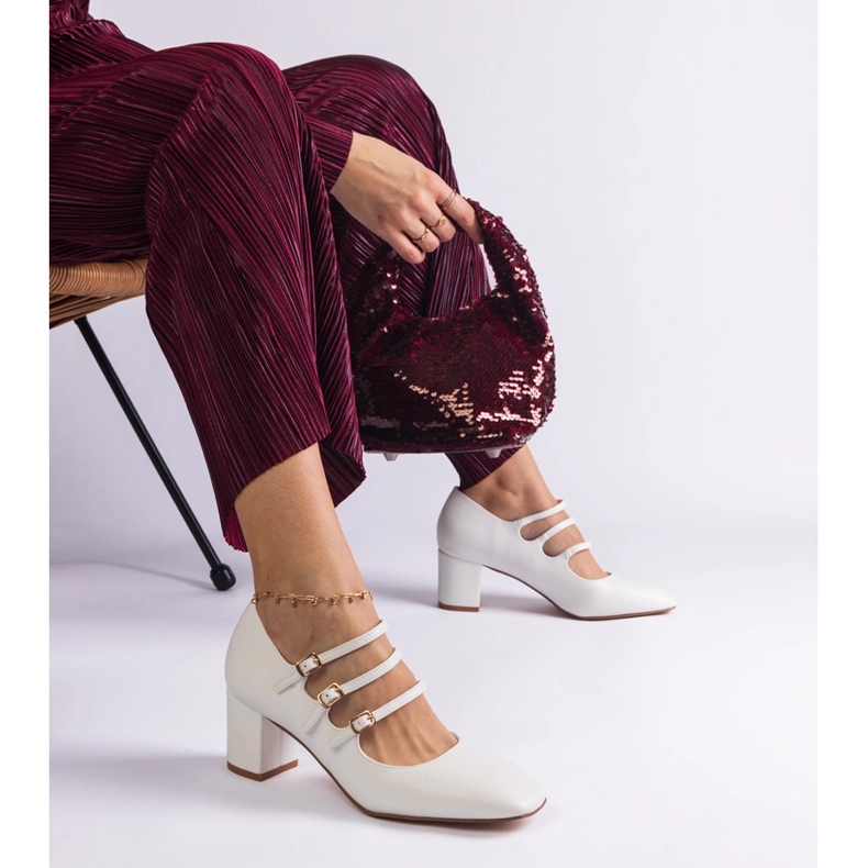 Fehér szivattyúk az oszlopon dekoratív csatokkal 1