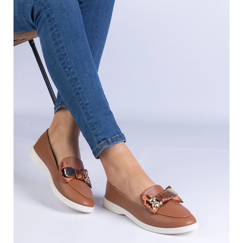 A barna cipők íj és egy arany mackó díszítéssel díszített 1