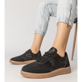 A fekete női cipők csillogással díszítették 1